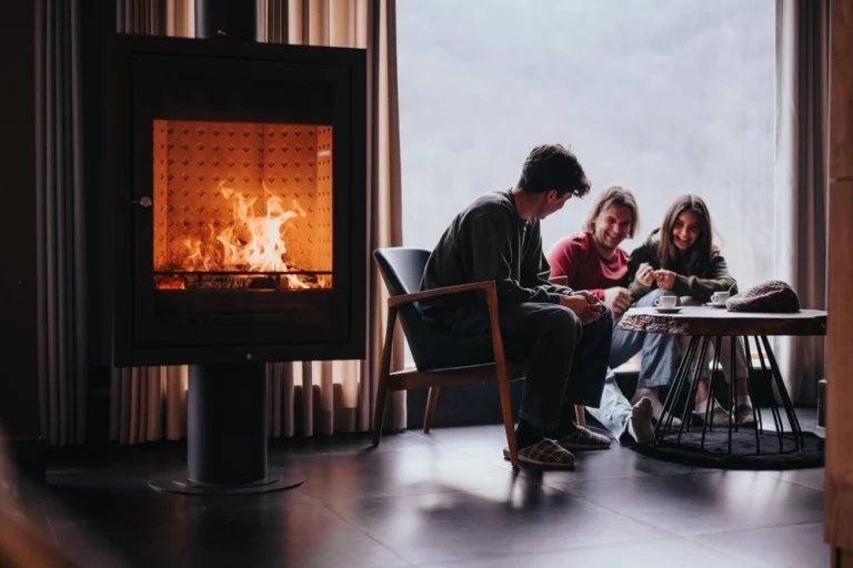 Eine warme und intime Szene von Freunden zu Hause versammelt, genießen die Gesellschaft des anderen durch einen glühenden Kamin.